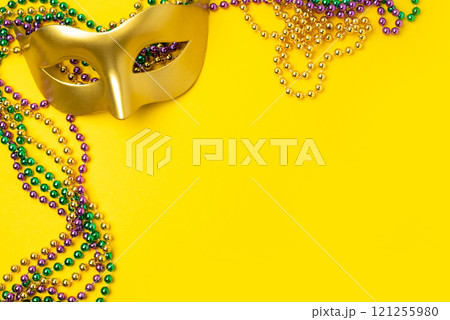 Mardi Gras beads on yellow background Mardi Gras beads on yellow background 121255980