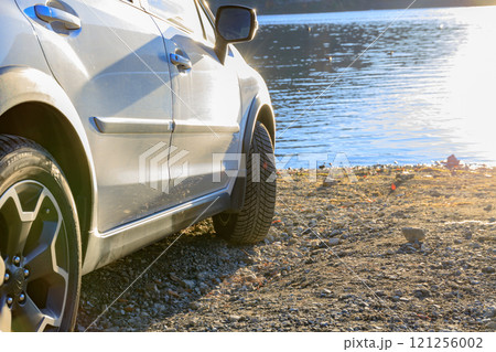 水際の砂利道でも安心して走行できるオールシーズンタイヤを履いたSUV 121256002
