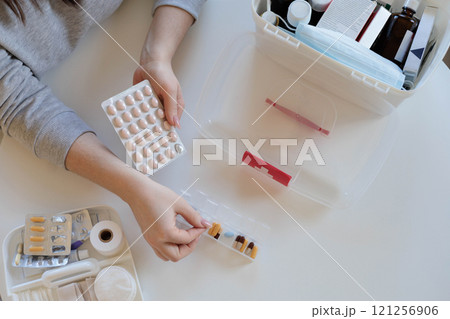 A woman takes her daily sedative or medicine for a headache or stomach pain. 121256906