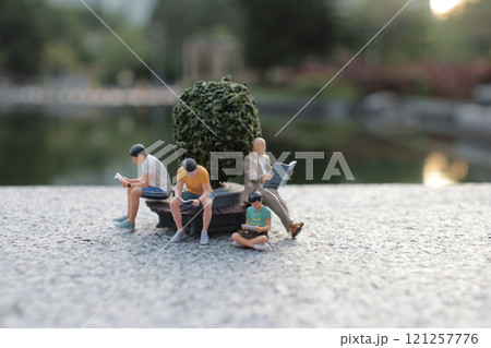 Miniature People Relaxing in Scenic Park Setting 121257776