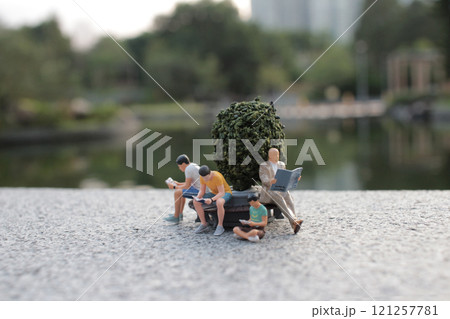 Miniature People Relaxing in Scenic Park Setting 121257781