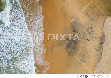 Top view beach with waves crashing on sandy shore,Beautiful waves sea surface in summer seascape background,Amazing beach colorful water background 121258024