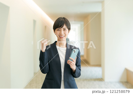 ガッツポーズをするスーツの女性 121258079