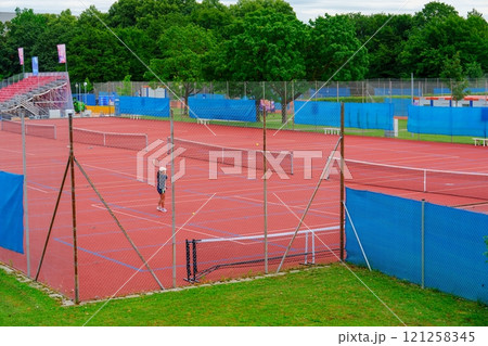 Scenic Tennis Court Surrounded by Lush Green Trees in Central Park, New York City, USA 121258345