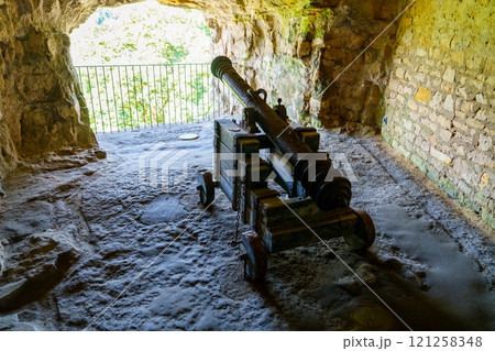 Ancient rusty cannon on display in a dark room of a castle in Luxembourg 121258348
