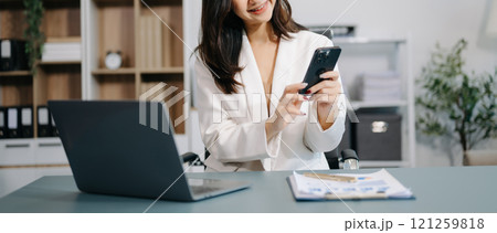 Young beautiful woman using laptop and tablet while sitting at her working place. Concentrated at work. Young beautiful woman using laptop and tablet while sitting at her working place. Concentrated at work. 121259818