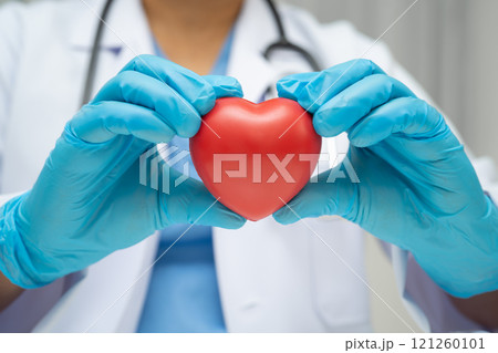 Asian woman doctor holding red heart for health in hospital. Asian woman doctor holding red heart for health in hospital. 121260101