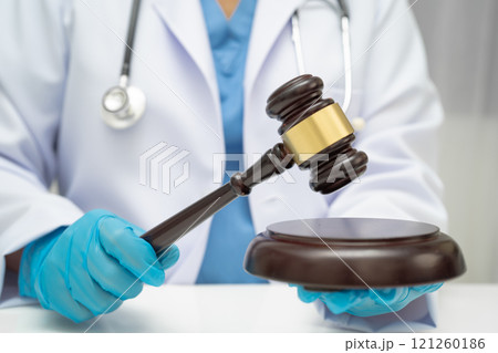 Asian doctor holding court hammer for and crime law justice, forensic medicine. Asian doctor holding court hammer for and crime law justice, forensic medicine. 121260186