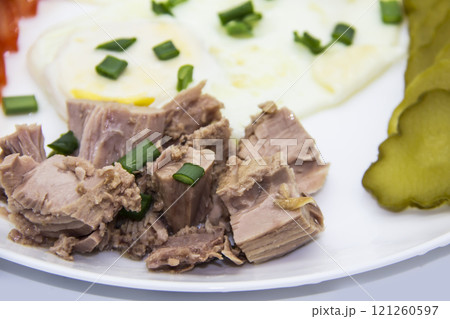 Delicious fresh tuna with eggs at the morning. Healthy and diet breakfast with tuna, eggs and vegetables on the white plate. 121260597