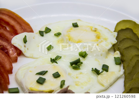 Delicious fresh tuna with eggs, tomatoes, cucmbers with green onion at the morning. Healthy and diet breakfast with tuna, eggs and vegetables on the white plate against white background 121260598