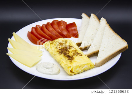 Amazing breakfast with tasty omelet, tomatoes, cheese, bread and sauce on the white plate. Delicious omelet made like rolle, other ingredients. Tasty and diet food. Healthy meal for breakfast or lunch Amazing breakfast with tasty omelet, tomatoes, cheese, bread and sauce on the white plate. Delicious omelet made like rolle, other ingredients. Tasty and diet food. Healthy meal for breakfast or lunch 121260628