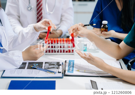 Medical team having a meeting with doctors in white lab coats and surgical scrubs seated Medical team having a meeting with doctors in white lab coats and surgical scrubs seated 121260806