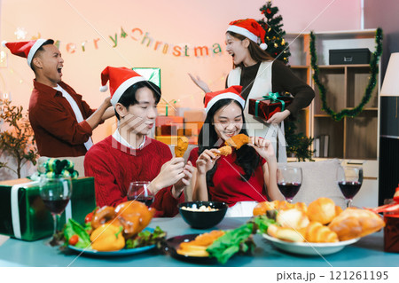 drinks and conversation, people celebrating together at Merry Christmas and Happy New Year. Friends are happy and celebrating with food, wine and friendship of love and gift exchange at the event. 121261195