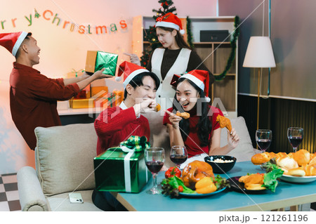 drinks and conversation, people celebrating together at Merry Christmas and Happy New Year. Friends are happy and celebrating with food, wine and friendship of love and gift exchange at the event. 121261196