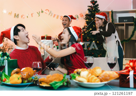 drinks and conversation, people celebrating together at Merry Christmas and Happy New Year. Friends are happy and celebrating with food, wine and friendship of love and gift exchange at the event. drinks and conversation, people celebrating together at Merry Christmas and Happy New Year. Friends are happy and celebrating with food, wine and friendship of love and gift exchange at the event. 121261197