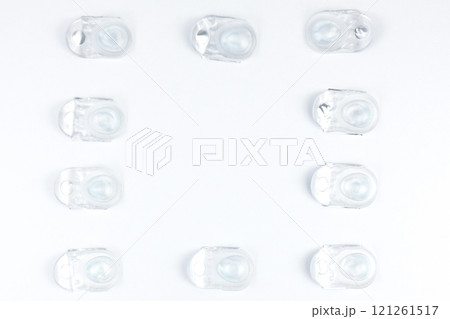 Disposable containers with lenses lying on a friend on a white background with space for text in the center. High quality photo 121261517