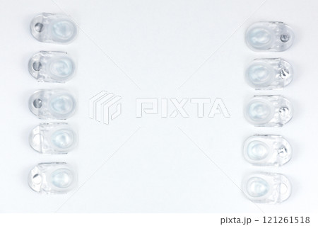 Daily contact lenses lie on the left and right of the photo in a row, with space for text on a white background. High quality photo Daily contact lenses lie on the left and right of the photo in a row, with space for text on a white background. High quality photo 121261518