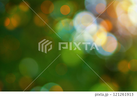 Green Summer Abstract Blurred Background With Large Translucent Round Highlights Of Light In Yellow, Blue Shade With Bokeh Effect And Sunlight Orange Pink Sunset Color. 121261913