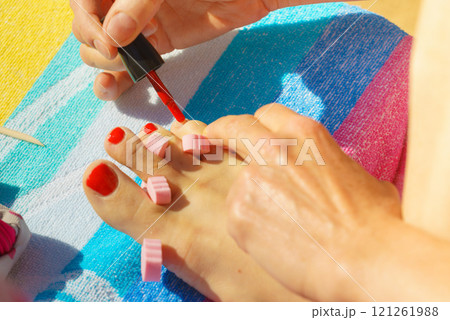 Woman pedicure with red nail polish 121261988