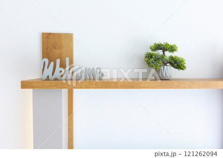 Cursive welcome sign on the shelf and bonsai 121262094