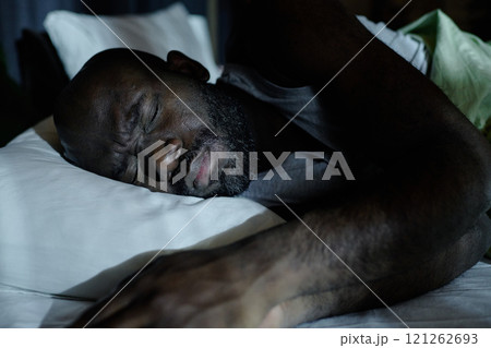 Medium close up of African American suffering from nightmare while sleeping in bed Medium close up of African American suffering from nightmare while sleeping in bed 121262693