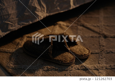 Medium close up of chocolate soft fur slippers on rug in bedroom Medium close up of chocolate soft fur slippers on rug in bedroom 121262703