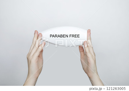 Female hands holding a can of shampoo, where it is written paraben free, no paraben. The concept of safe composition of shampoo without aggressive components 121263005