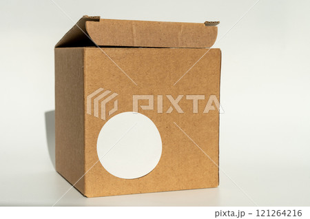 National Cartonnage Day. Cardboard box with white round sticker. Minimal product packaging design National Cartonnage Day. Cardboard box with white round sticker. Minimal product packaging design 121264216
