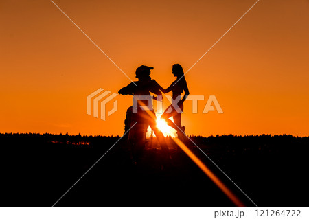 Silhouette of a girl and a man on a motorcycle. Silhouette of a girl and a man on a motorcycle. 121264722