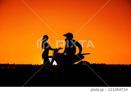 Silhouette of a girl and a man on a motorcycle.  121264724