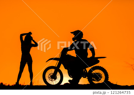Silhouette of a girl and a man on a motorcycle.  121264735