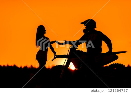 Silhouette of a girl and a man on a motorcycle.  121264737