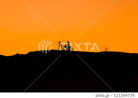 Silhouette of a girl and a man on a motorcycle. Silhouette of a girl and a man on a motorcycle. 121264739