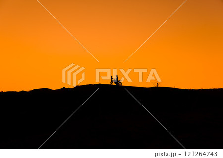 Silhouette of a girl and a man on a motorcycle. Silhouette of a girl and a man on a motorcycle. 121264743