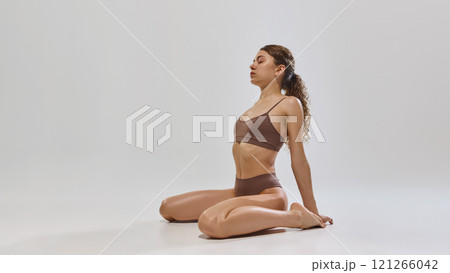 Young woman showcases toned physique, highlighting movement, health, and style with modern minimalism and timeless natural beauty. Young woman showcases toned physique, highlighting movement, health, and style with modern minimalism and timeless natural beauty. 121266042