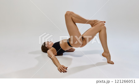 Fitness model displays flexibility with stylish athletic wear highlighting balance, control, and power while promoting body positivity and mindful movement. 121266051