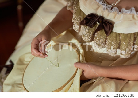 Close up of embroidery process with focus on hands threading needle and creating patterns on fabric, copy space 121266539