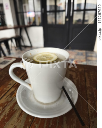 A steaming cup of hot lemon water, garnished with a lemon slice. A steaming cup of hot lemon water, garnished with a lemon slice. 121267620