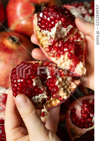 Hands open the pomegranate, separation into parts, pomegranates grains Hands open the pomegranate, separation into parts, pomegranates grains 121269057