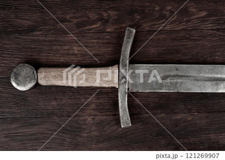 Medieval sword on wooden backgrond. Medieval sword on wooden backgrond. 121269907