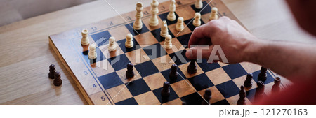 Top view close up of unrecognizable man playing chess with focus on hand moving pawn piece copy space Top view close up of unrecognizable man playing chess with focus on hand moving pawn piece copy space 121270163