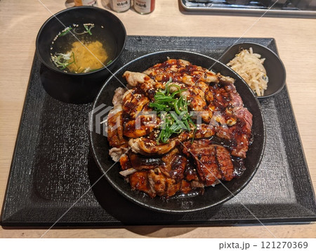 ランチョンマットの上の鰻蒲焼きを卵でとじたうな玉丼とお吸い物のセット 121270369