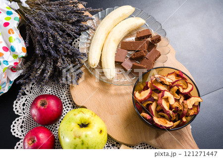 Fresh and dried fruits, chocolate, and lavender on a table. 121271447