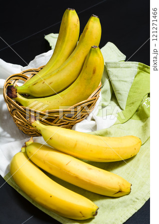 Ripe yellow bananas in a basket and on a cloth. 121271466