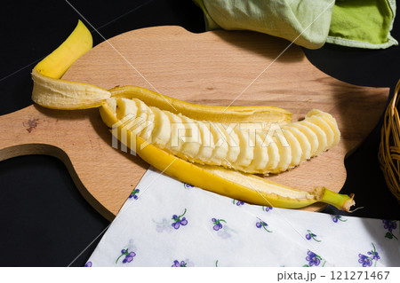 Sliced banana on a wooden cutting board. 121271467