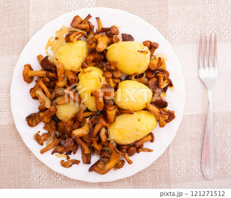 Delicious fried chanterelles with new potatoes on a white plate top view Delicious fried chanterelles with new potatoes on a white plate top view 121271512