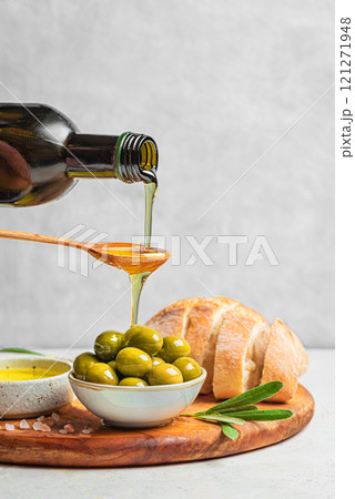 Pouring Olive Oil over Green Olives Pouring Olive Oil over Green Olives 121271948