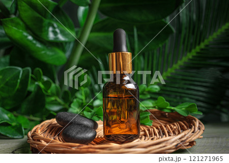 Essential oil dropper and tropical green leaves Essential oil dropper and tropical green leaves 121271965