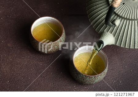 Pouring green tea into cups Pouring green tea into cups 121271967