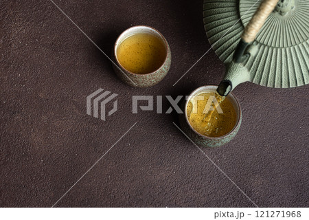 Pouring fresh tea into cups Pouring fresh tea into cups 121271968